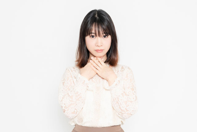 喉を押さえる女性